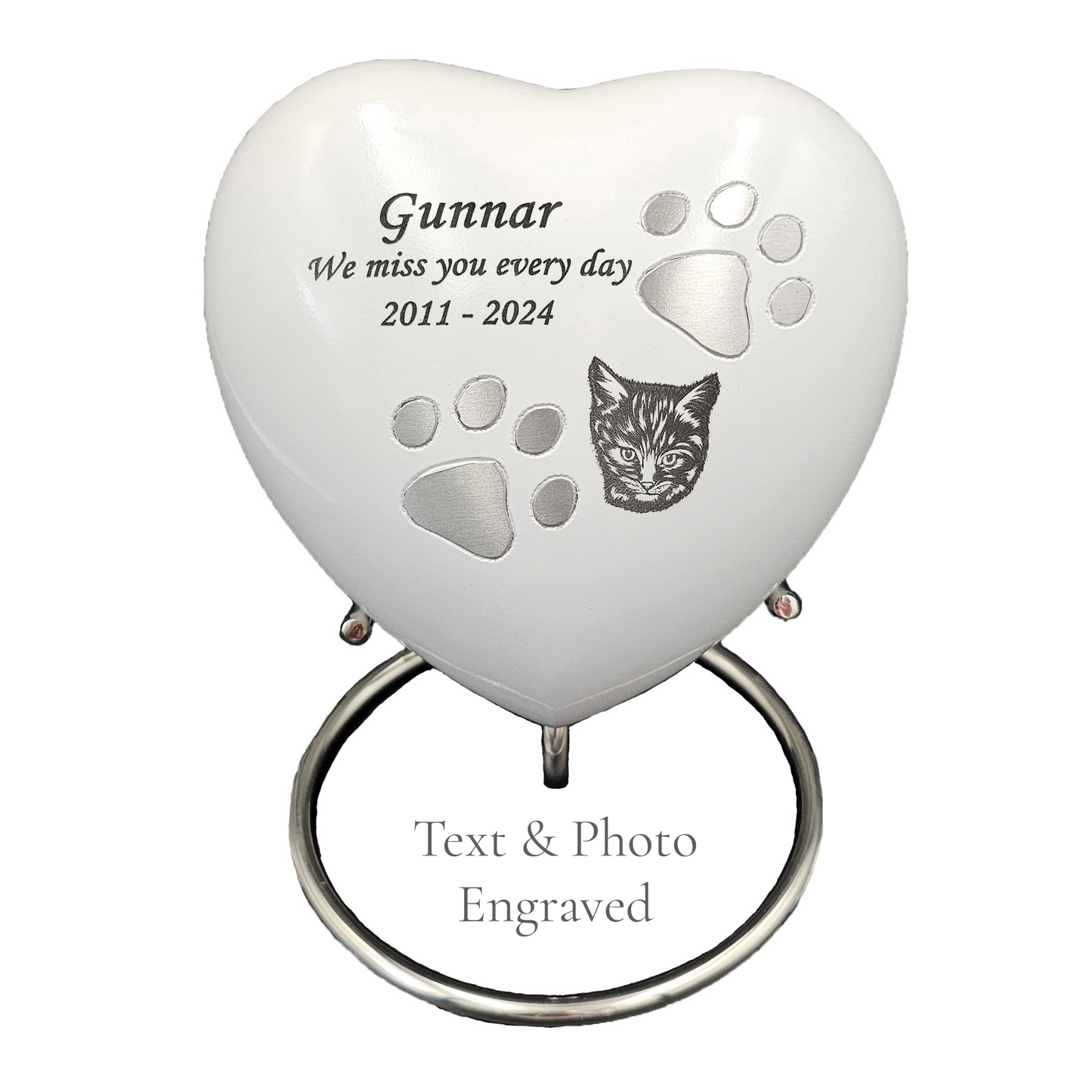 Heart-shaped pet memorial with engraved text and paw prints on a white heart urn