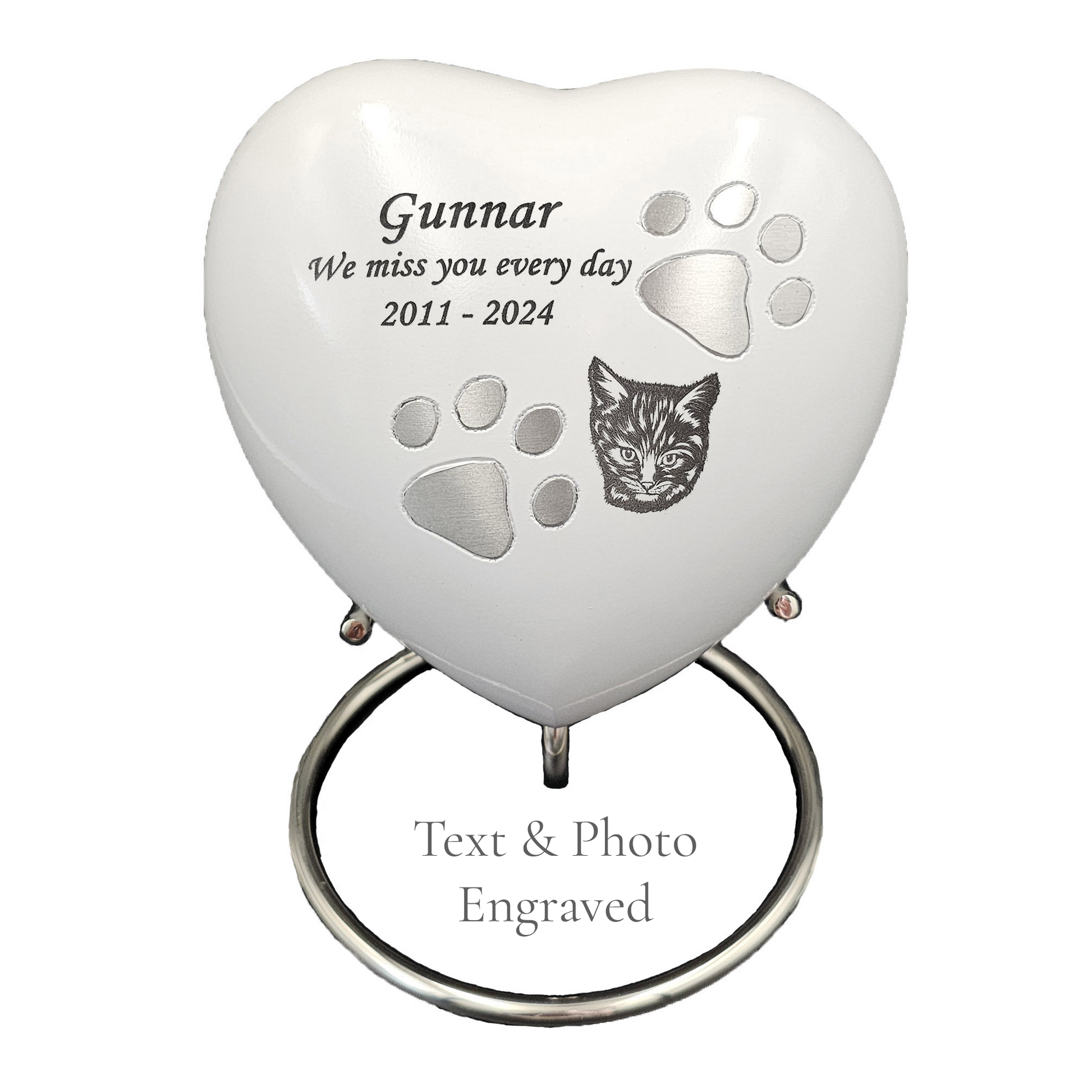 Heart-shaped pet memorial with engraved text and paw prints on a white heart urn