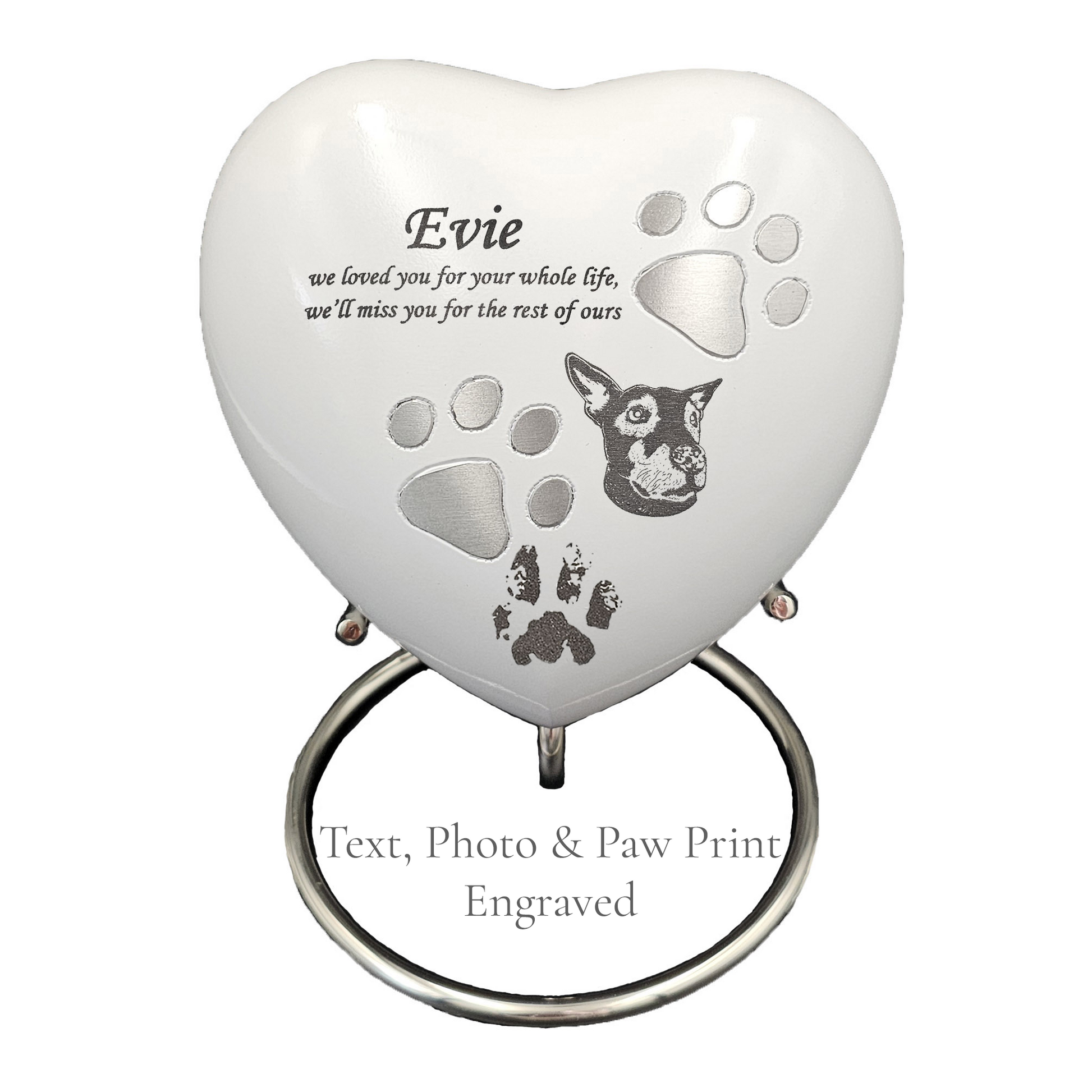 Heart-shaped pet memorial with engraved text and paw prints on a white urn