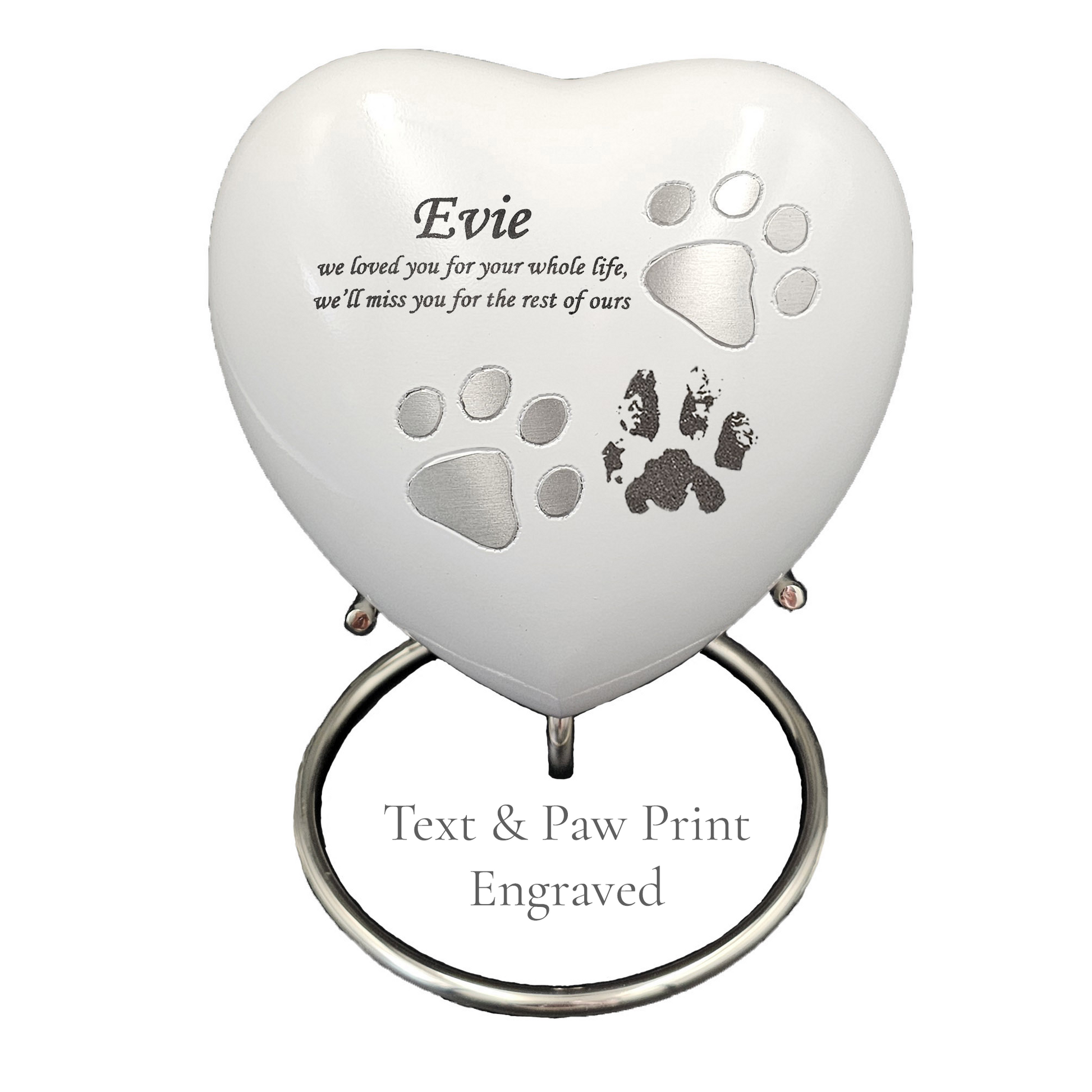 Heart-shaped pet memorial with engraved text and paw prints on a white heart urn